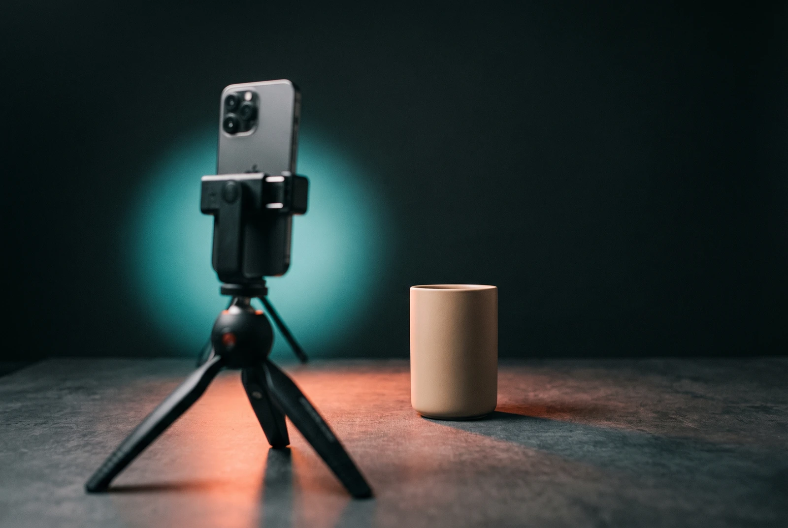Smartphone auf einem kleinen Stativ, davor ein Produkt im Licht